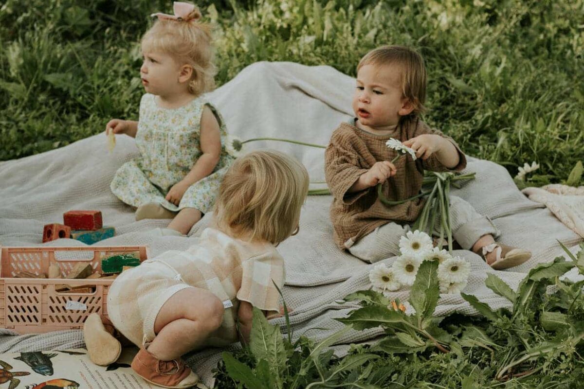 a group of children sitting on a blanket