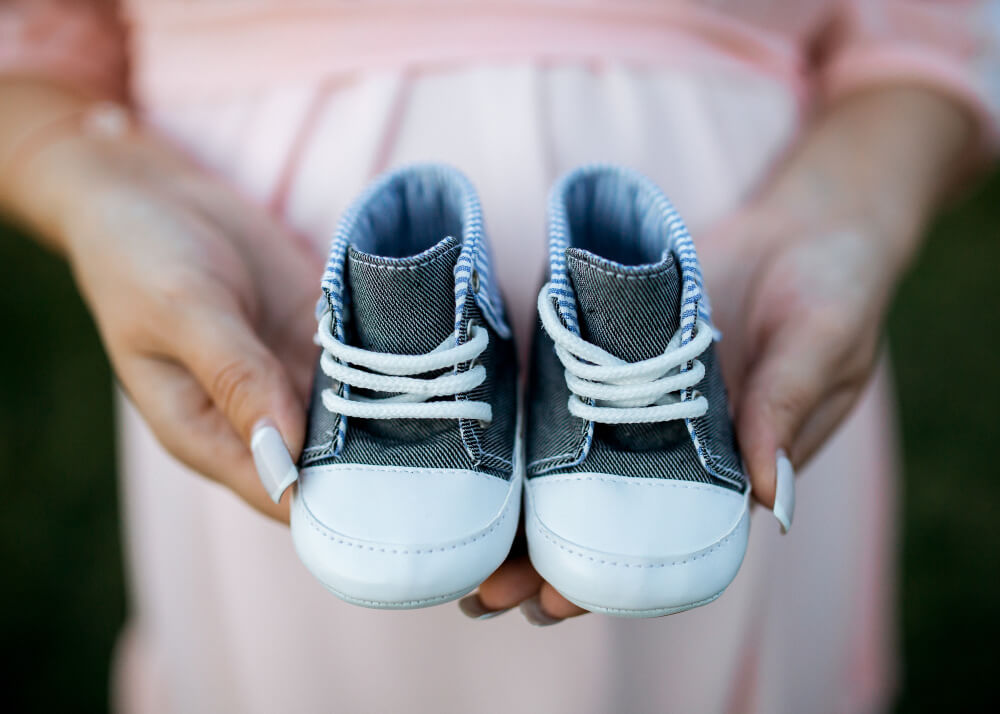 a person holding a pair of baby shoes